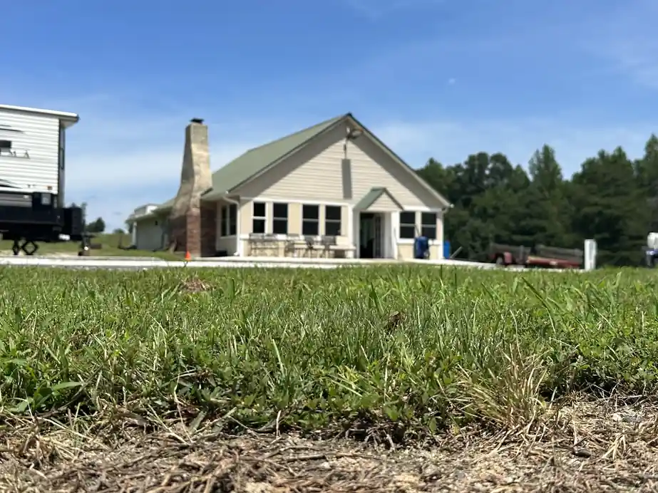 The green-roofed clubhouse with its stone chimney, seen from the lawn