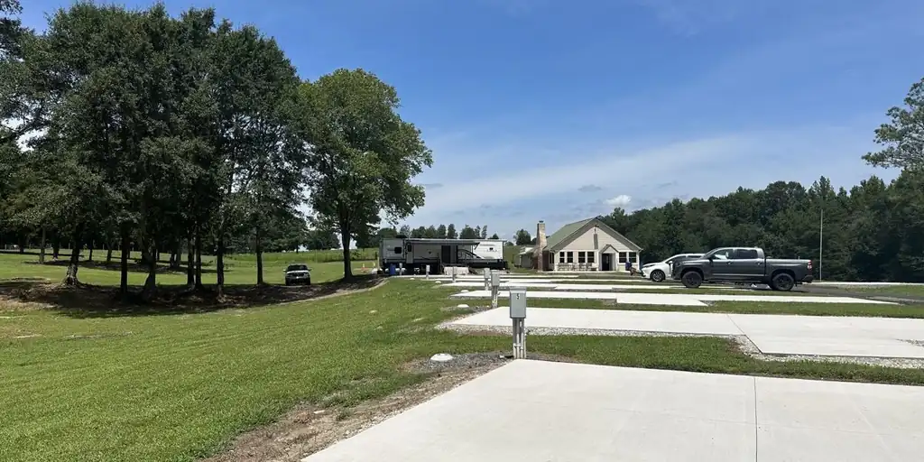 Row of concrete pads with utility pedestals and the clubhouse in the distance